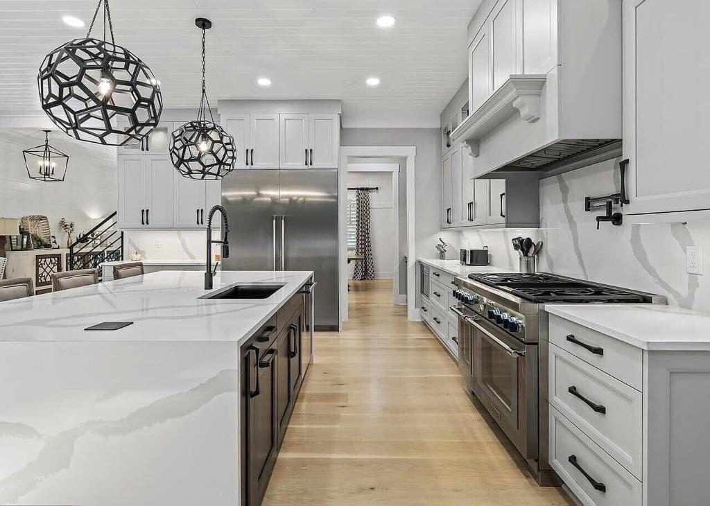 A large kitchen with white cabinets and stainless steel appliances.