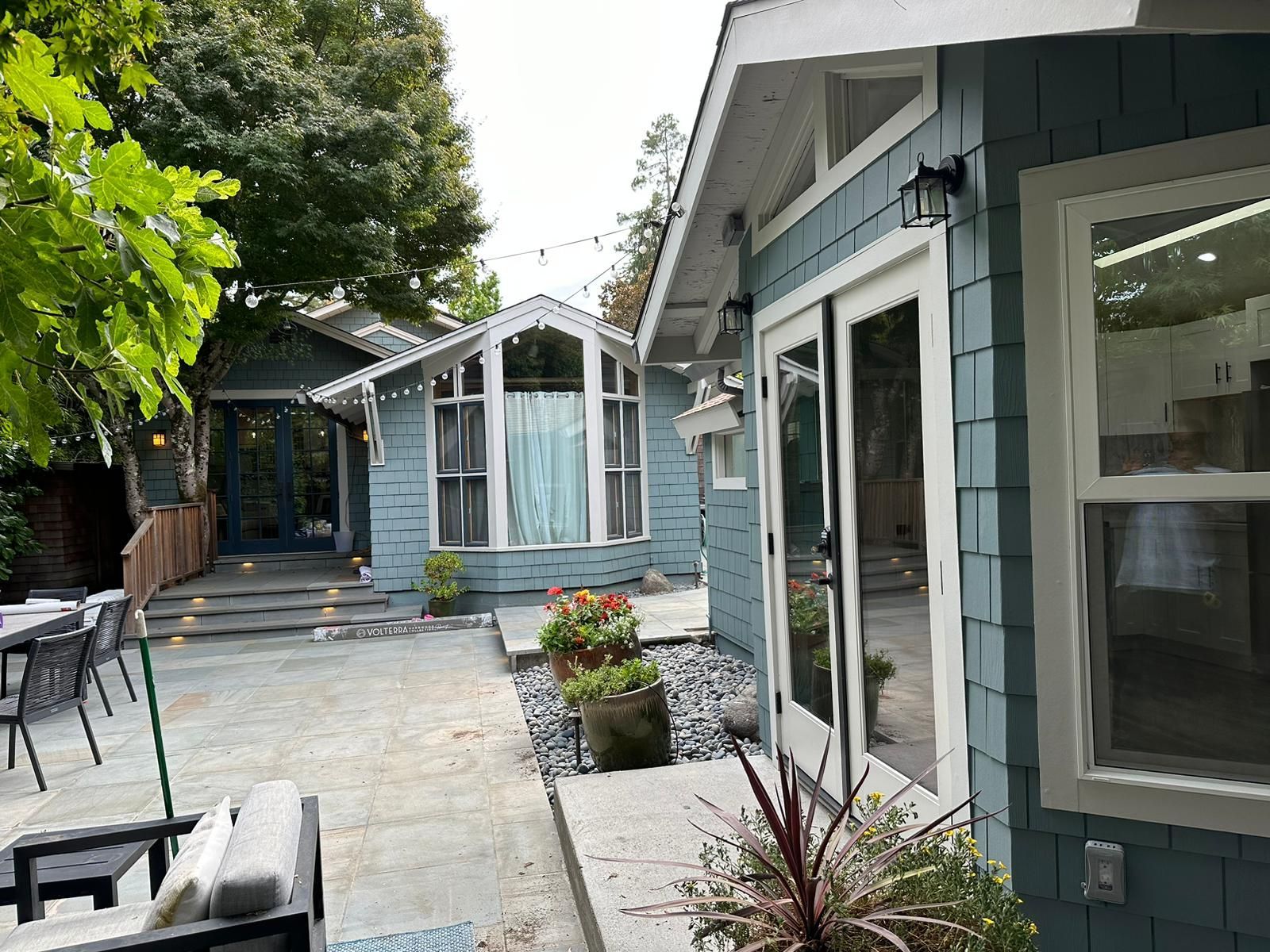 A blue house with a patio in front of it
