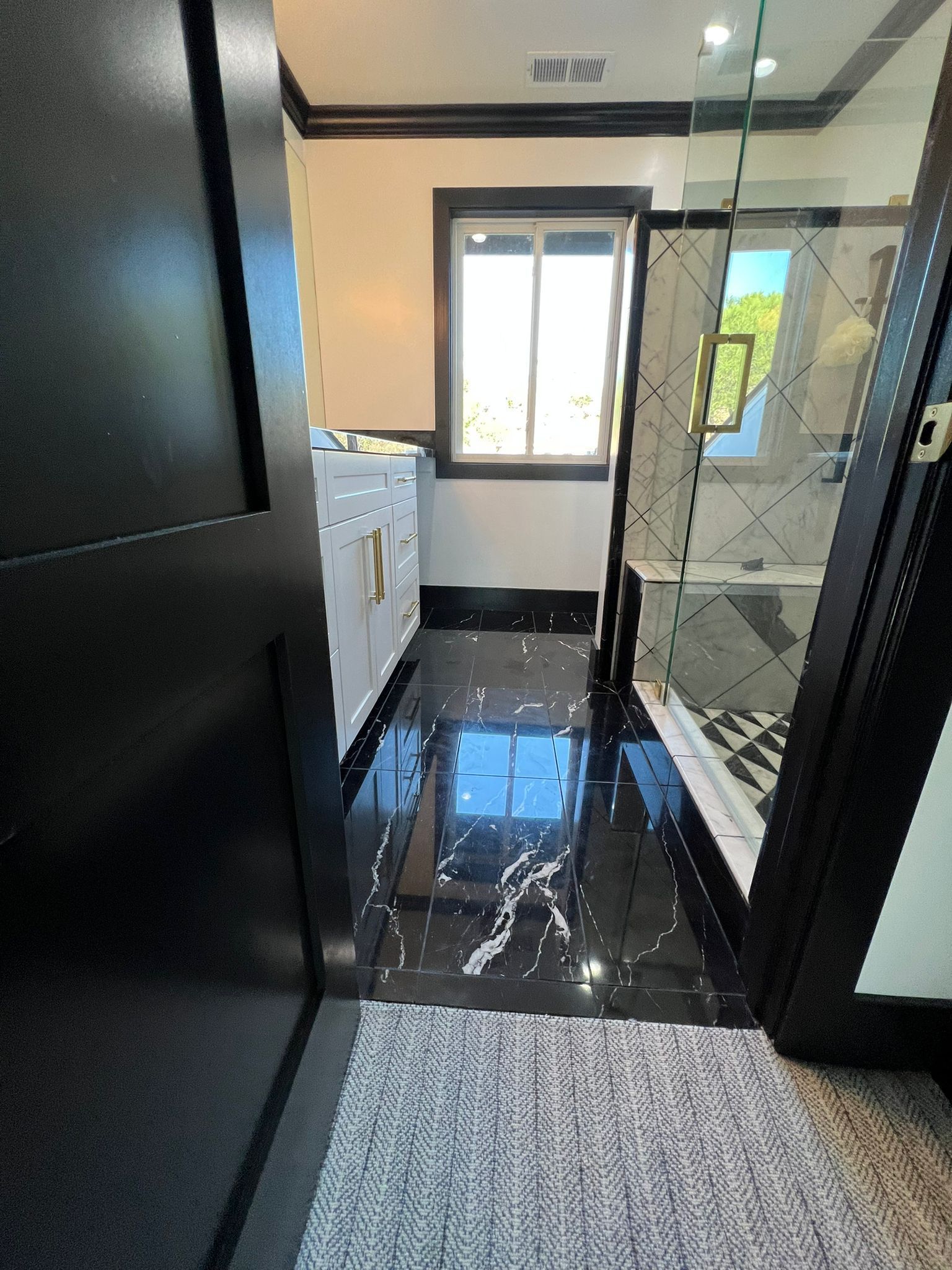A bathroom with a walk in shower and a window.