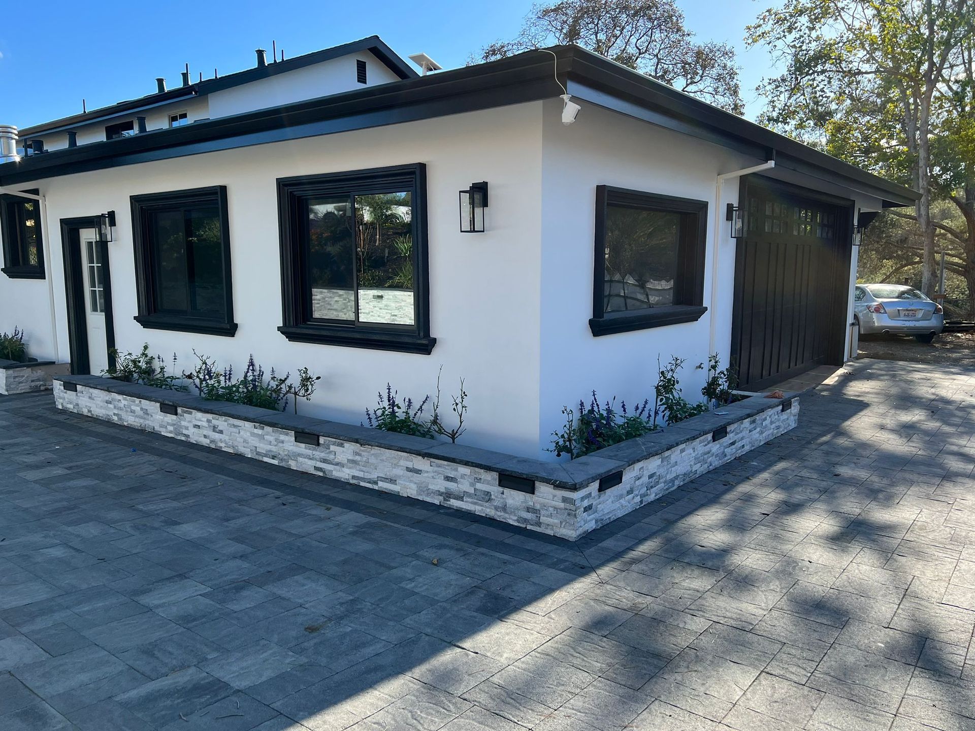 A white house with black windows and a black garage door