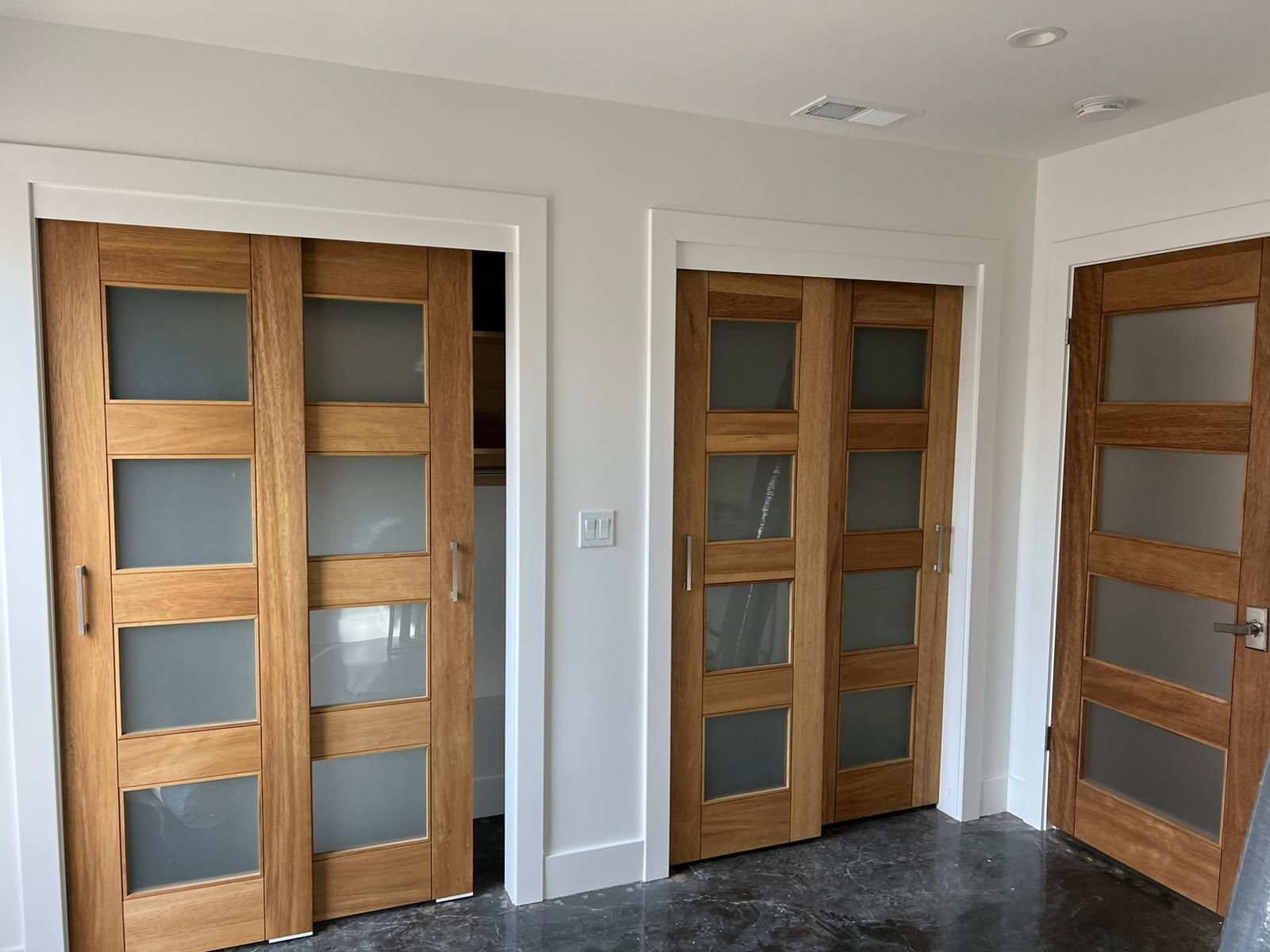 A room with a lot of wooden doors with frosted glass