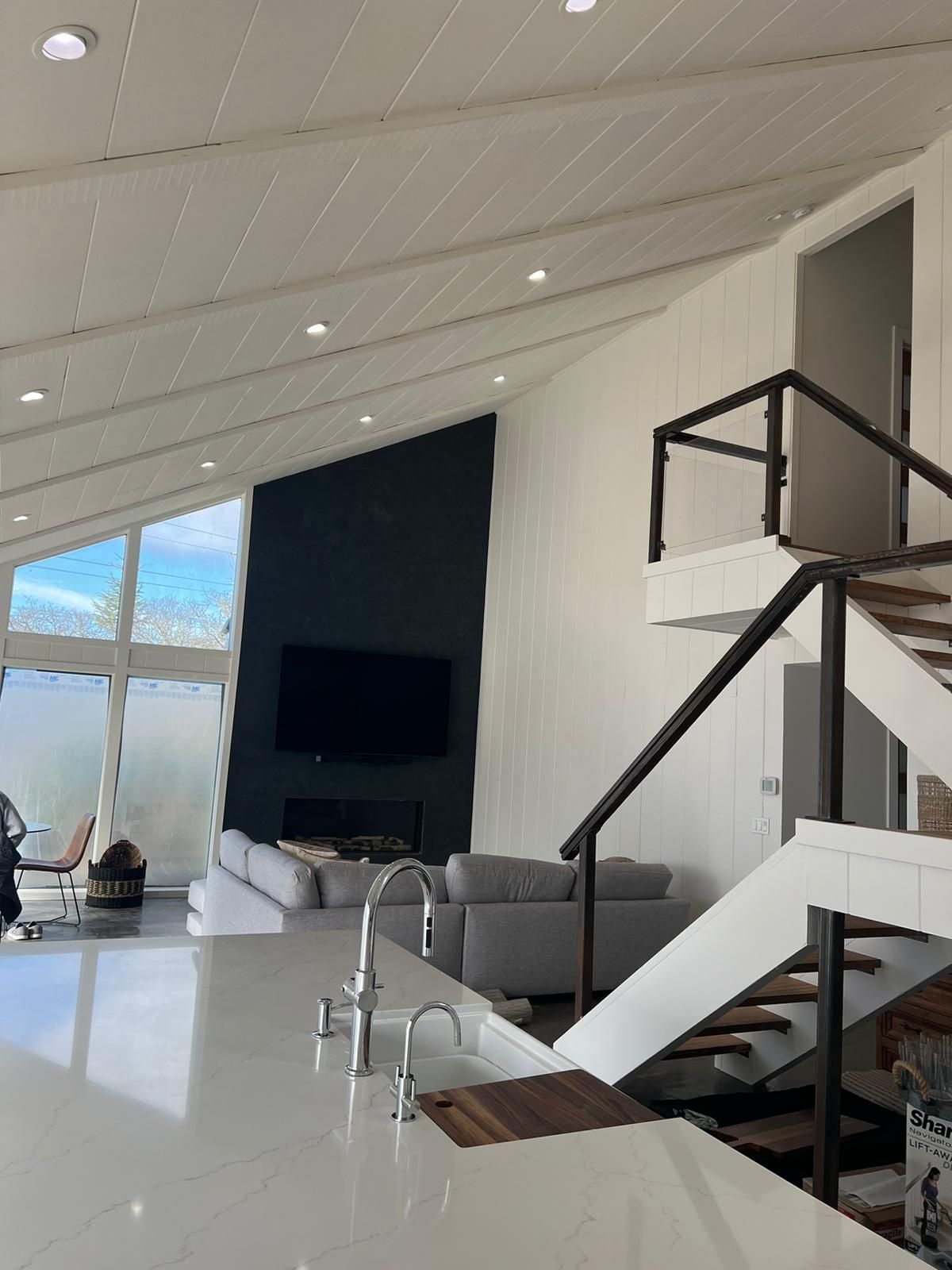 A living room with stairs leading up to the second floor