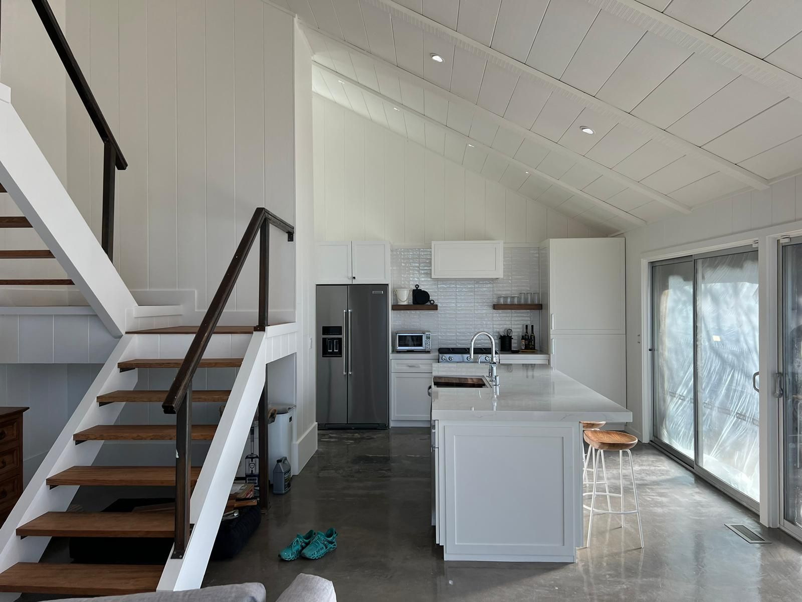 A kitchen with a staircase leading up to the second floor