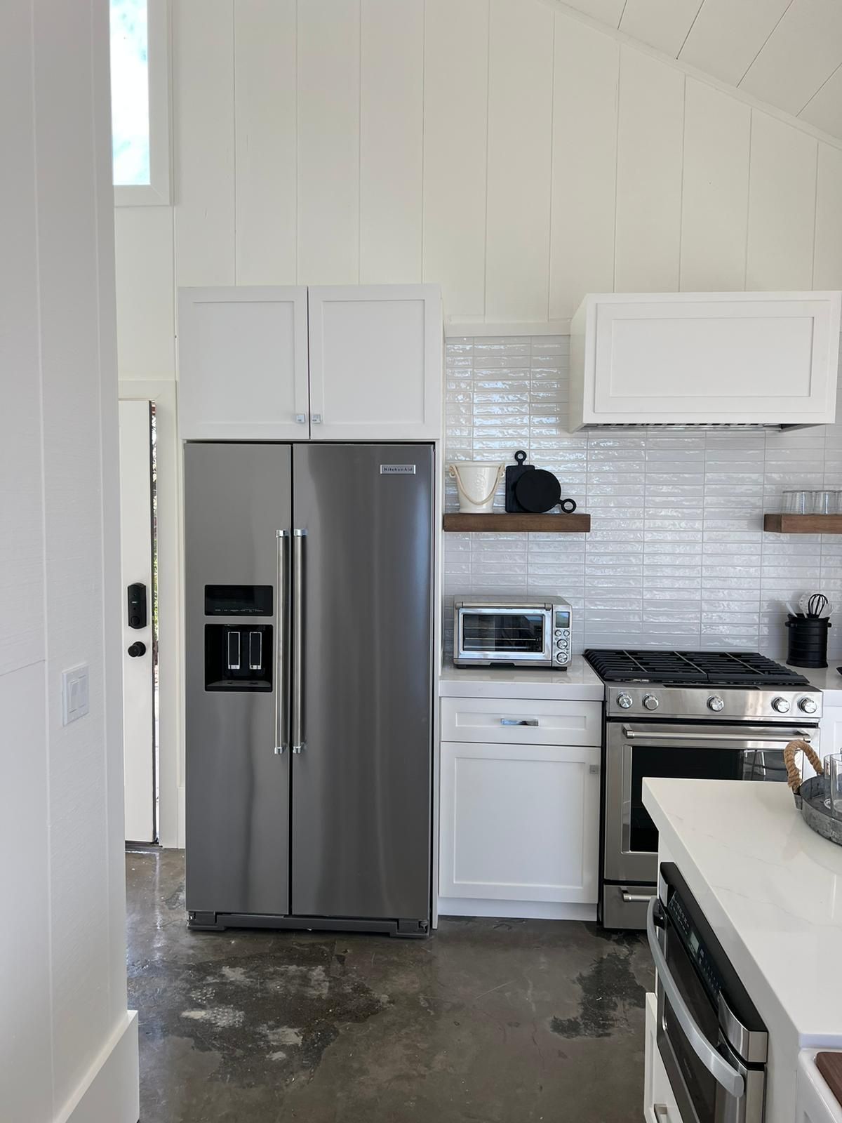 A kitchen with stainless steel appliances and white cabinets