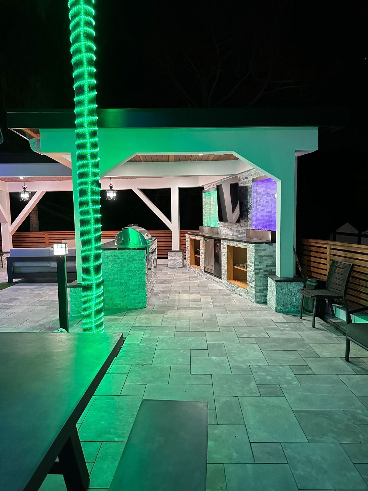 A patio with a green light hanging from a pole.