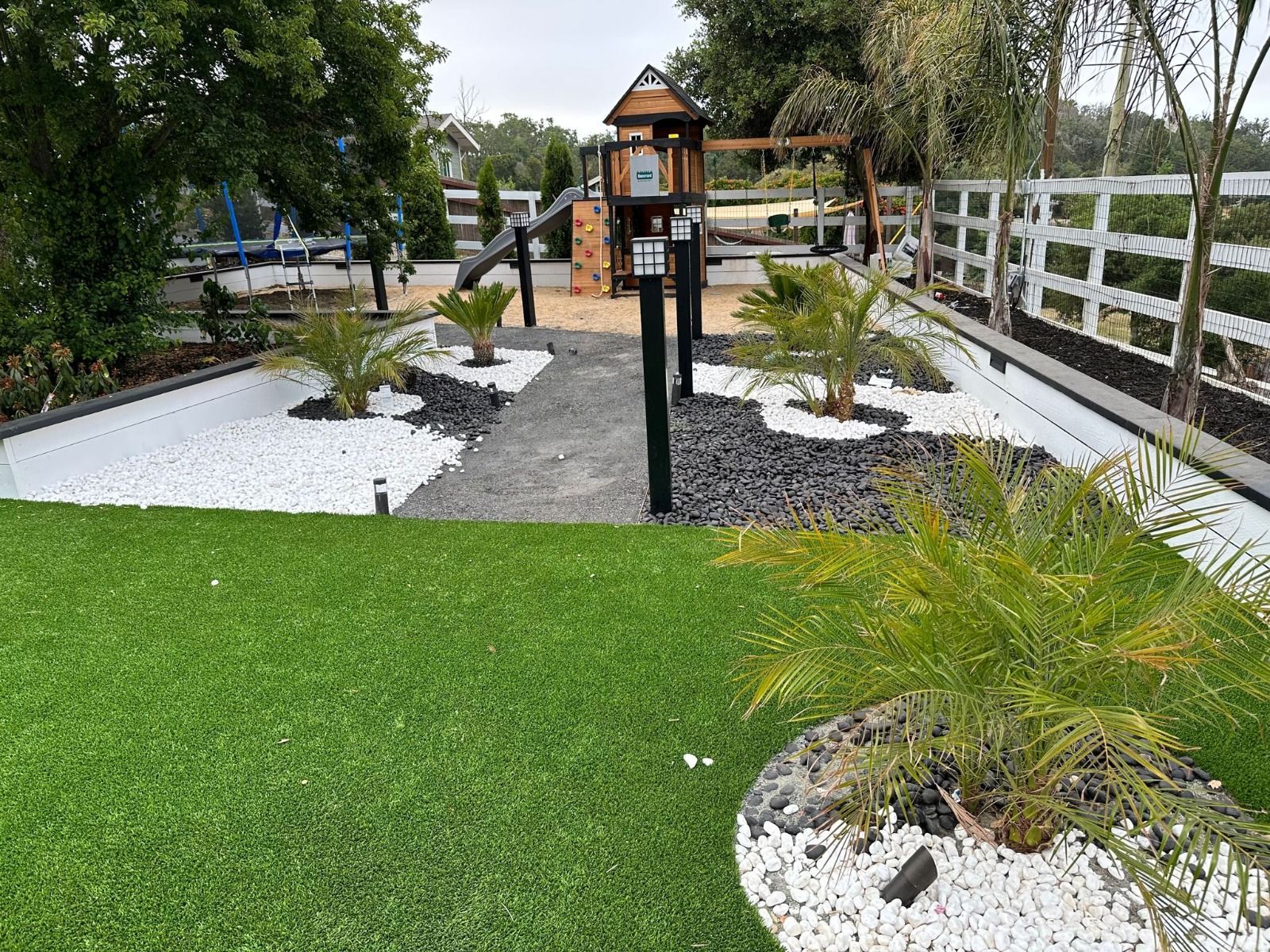 A lush green lawn with a playground in the background.