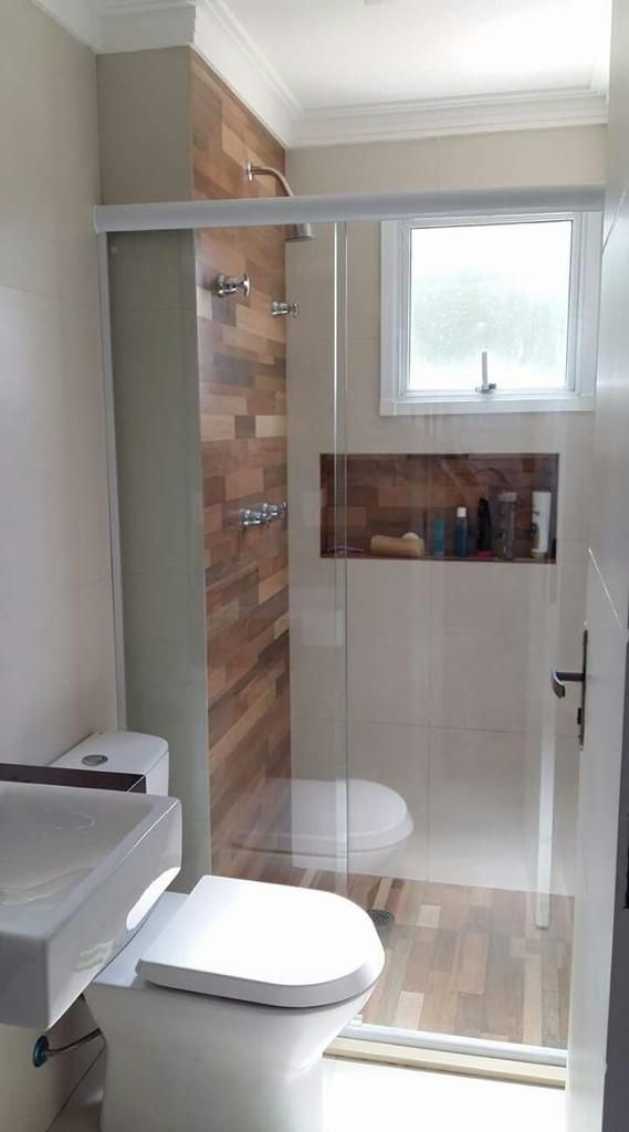 A bathroom with a toilet , sink , shower and window.