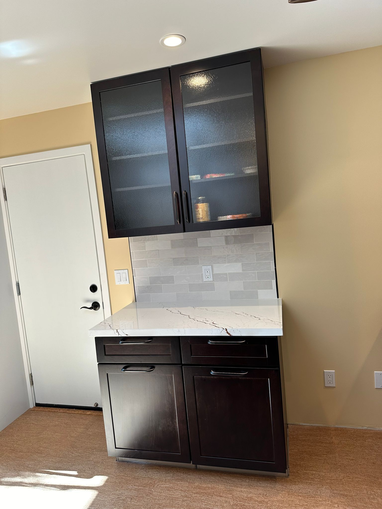 A kitchen with black cabinets and a white counter top
