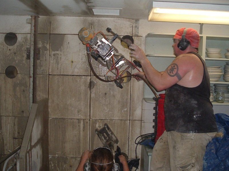 Contractor working with machine in cleaning the walls