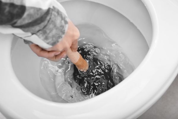 plumber unclogging toilet in residential home in Worcester Massachusetts