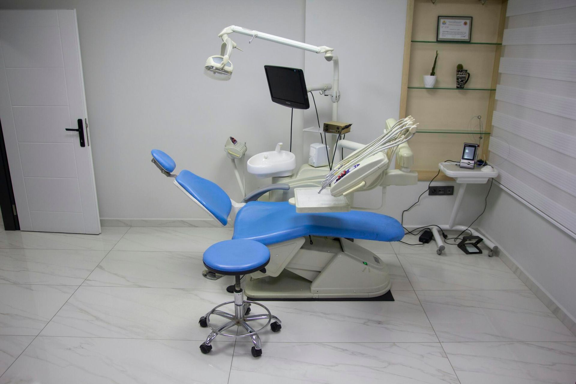 Dental clinic with blue and white chair, tools, and equipment.