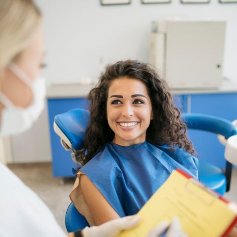 A woman is getting her teeth examined by a dentist.