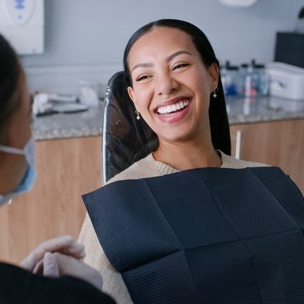 A woman is getting her teeth examined by a dentist.