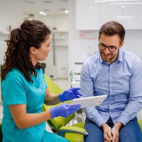 A woman is getting her teeth examined by a dentist.