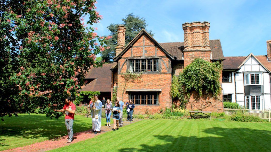 a group of people are walking in front of a large brick house .