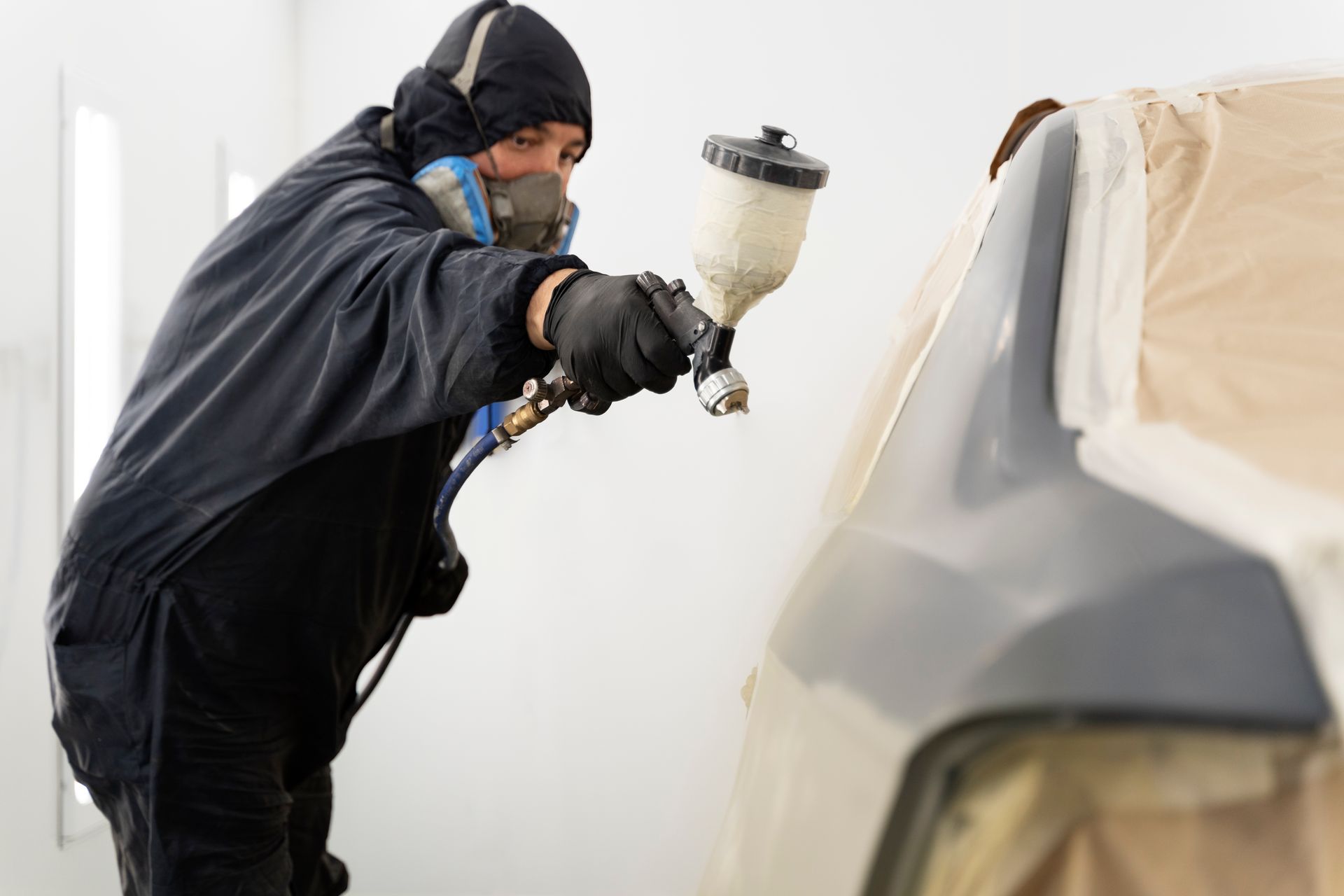 Person applying car wax with a blue applicator to a gray car door.
