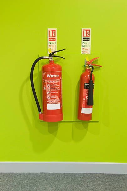 Red Fire Extinguishers on A Green Wall — Montrose, CO — Frontline Fire Defense