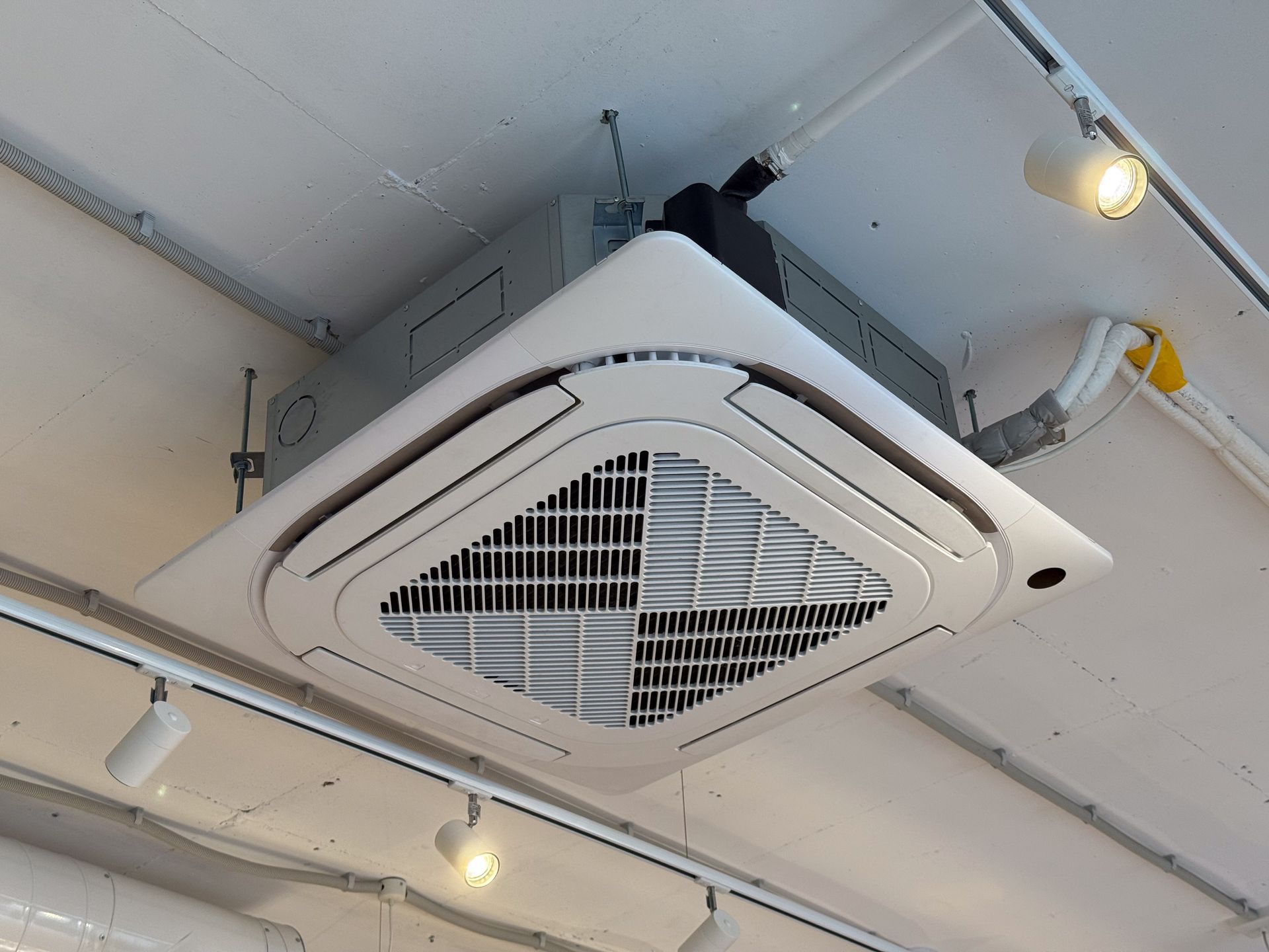 Ceiling mounted air conditioning unit in a modern commercial interior. Ceiling mounted air conditioning unit in a modern commercial interior.