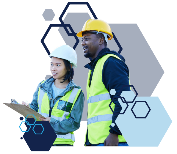 A man and a woman wearing hard hats and safety vests are looking at a clipboard.