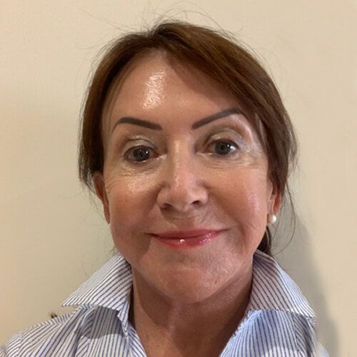 Woman with brown hair and a blue and white striped shirt smiling at the camera.