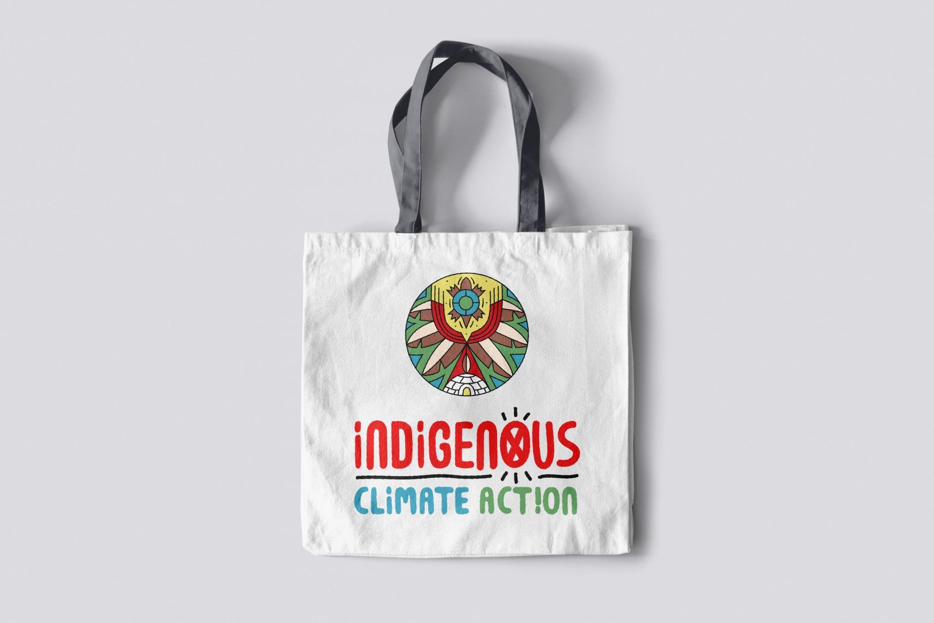 A white tote bag with indigenous climate action written on it.