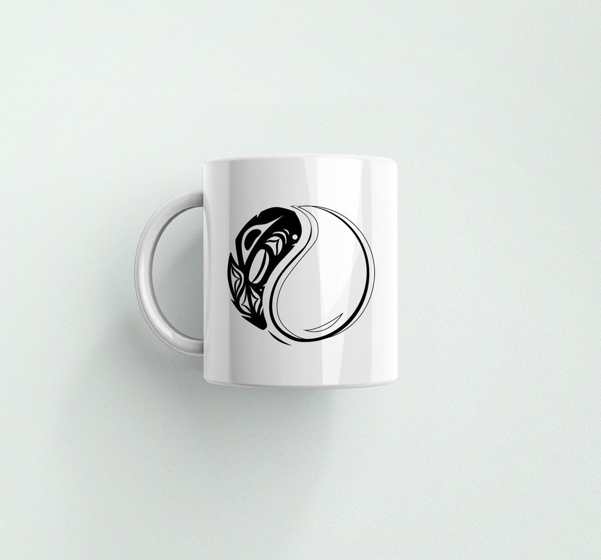 A white coffee mug with a black and white drawing of a tennis ball on it.