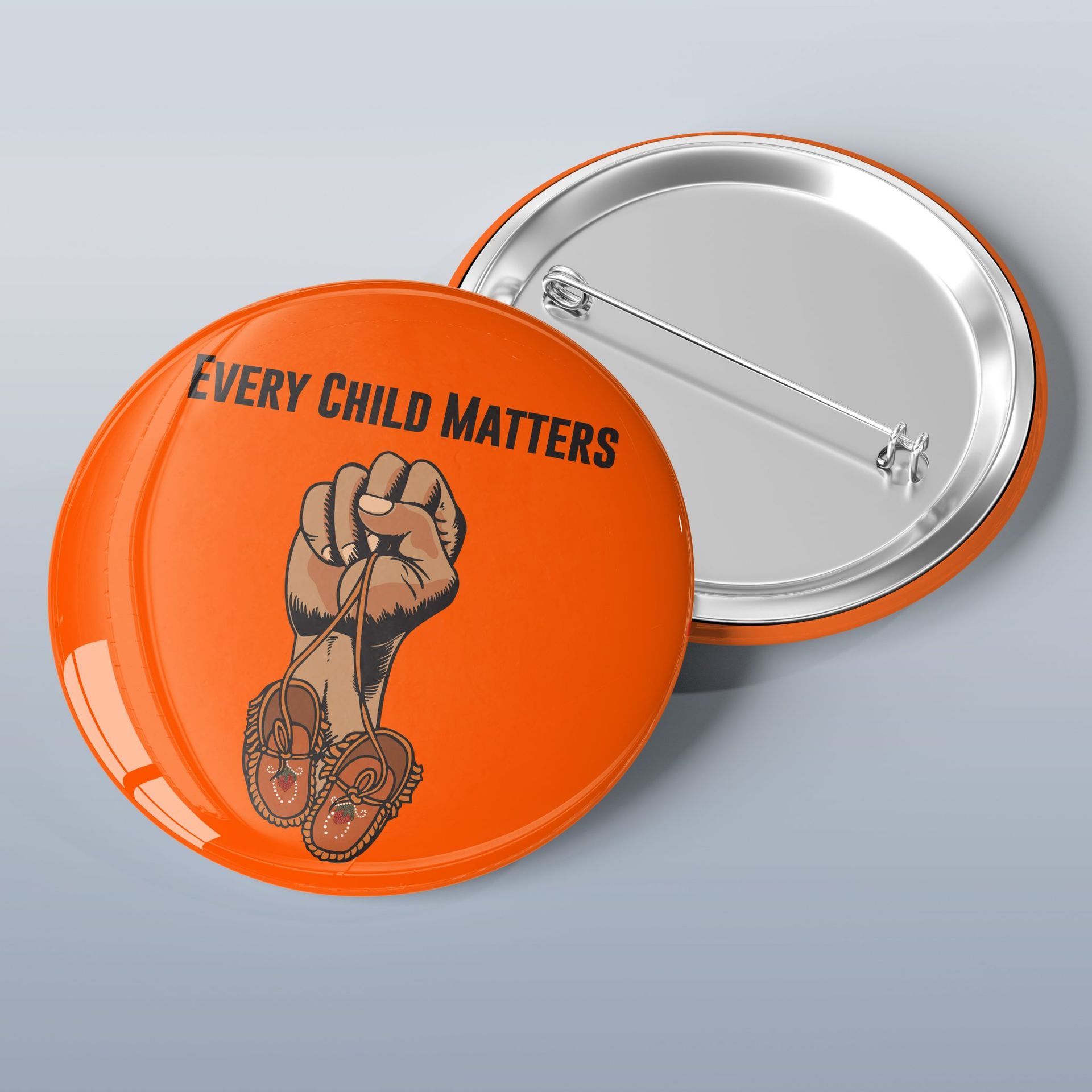 A button that says every child matters on it