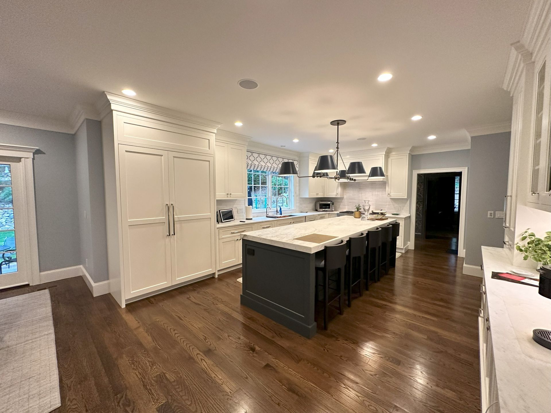 A kitchen with white cabinets and a large island in the middle.