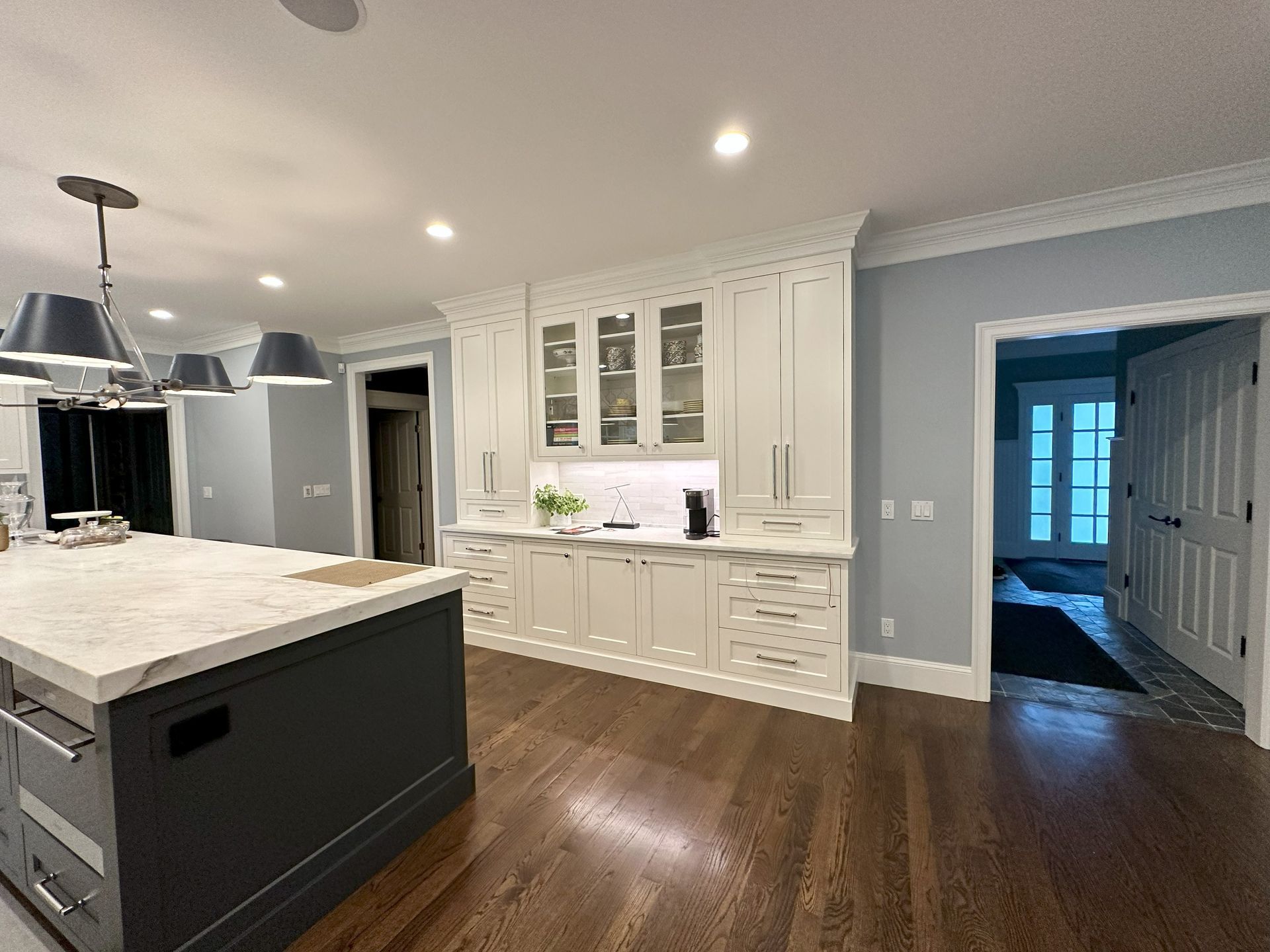 A kitchen with white cabinets and a large island.