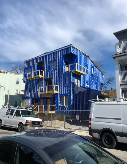 A blue building with a white van parked in front of it