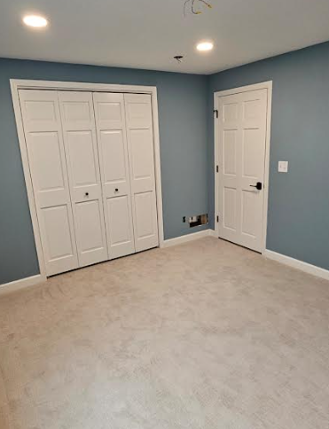 An empty room with blue walls and white doors.