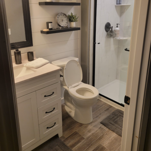 A bathroom with a toilet a sink and a shower
