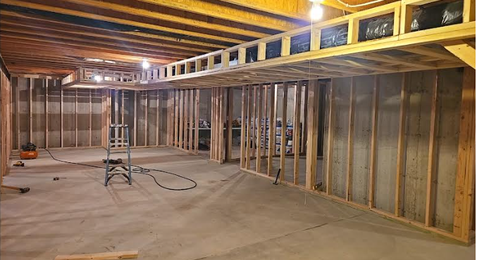 A basement under construction with wooden beams and a ladder.