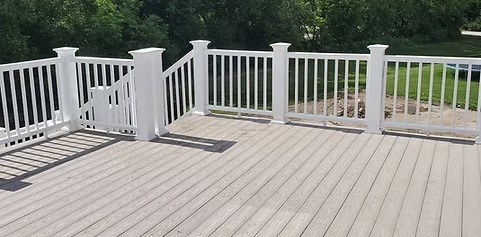 A large deck with a white railing and stairs.