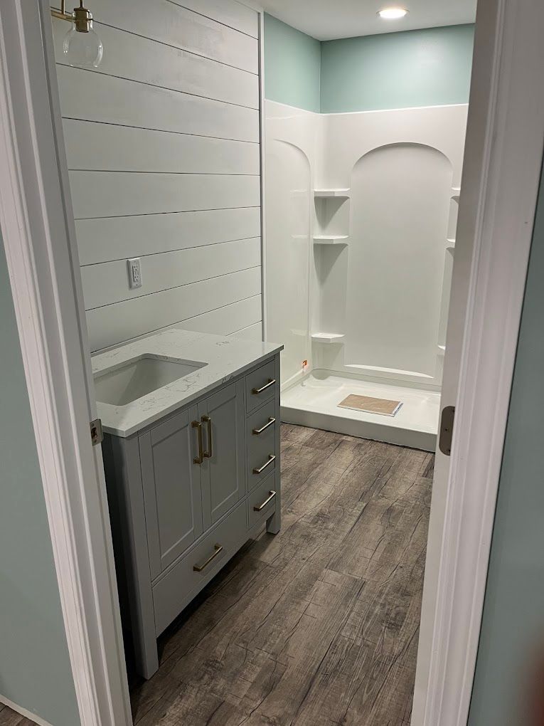 A bathroom with a sink and a shower.