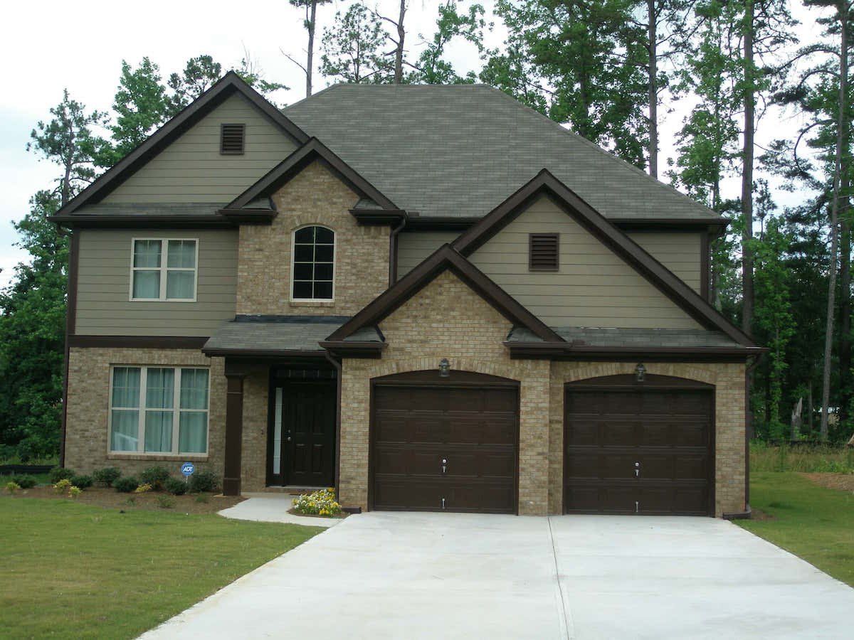 Two-story home with brown trim and two, single-car garages