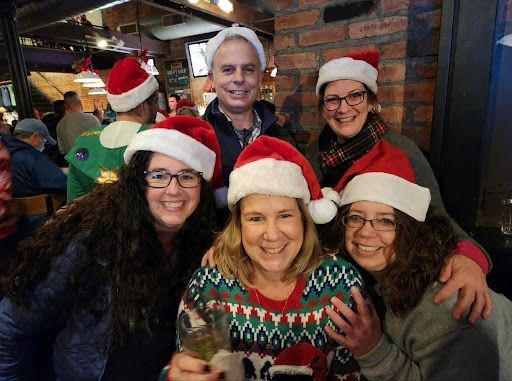 A group of people wearing santa hats are posing for a picture.