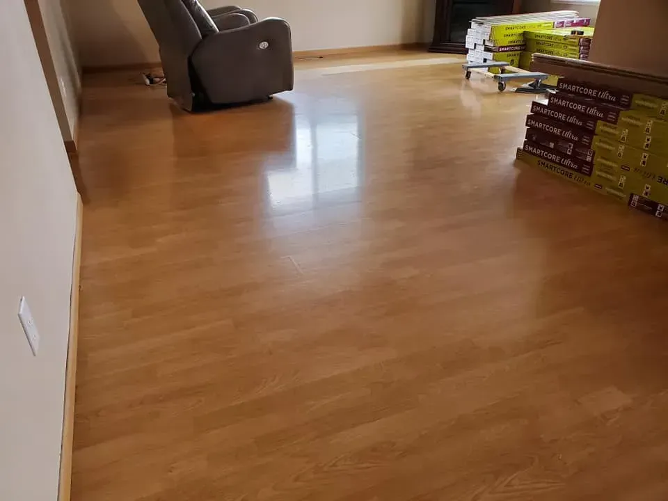 A living room with a wooden floor and a chair.