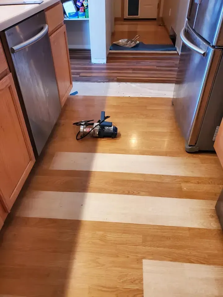 A kitchen with wooden floors and stainless steel appliances.