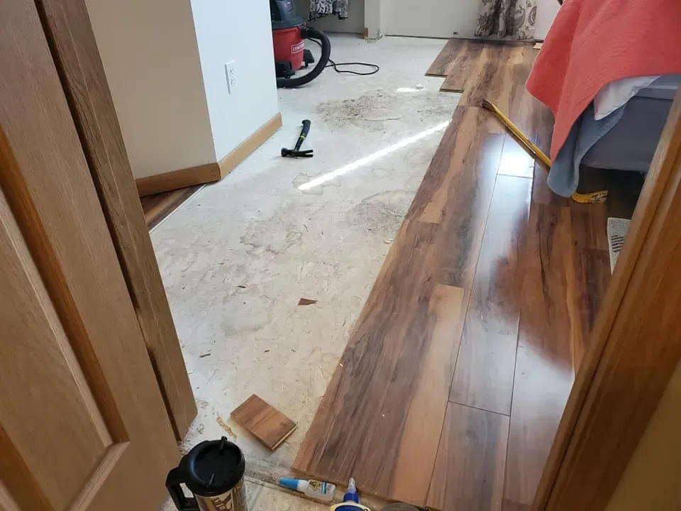 A wooden floor is being installed in a room.