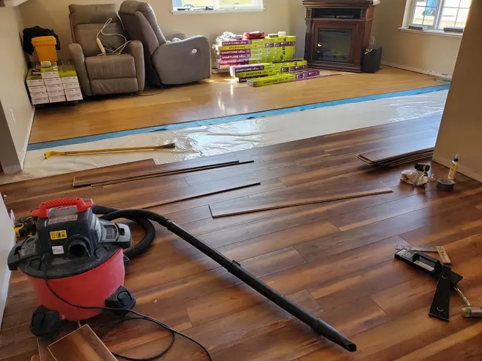 A vacuum cleaner is sitting on a wooden floor in a living room.