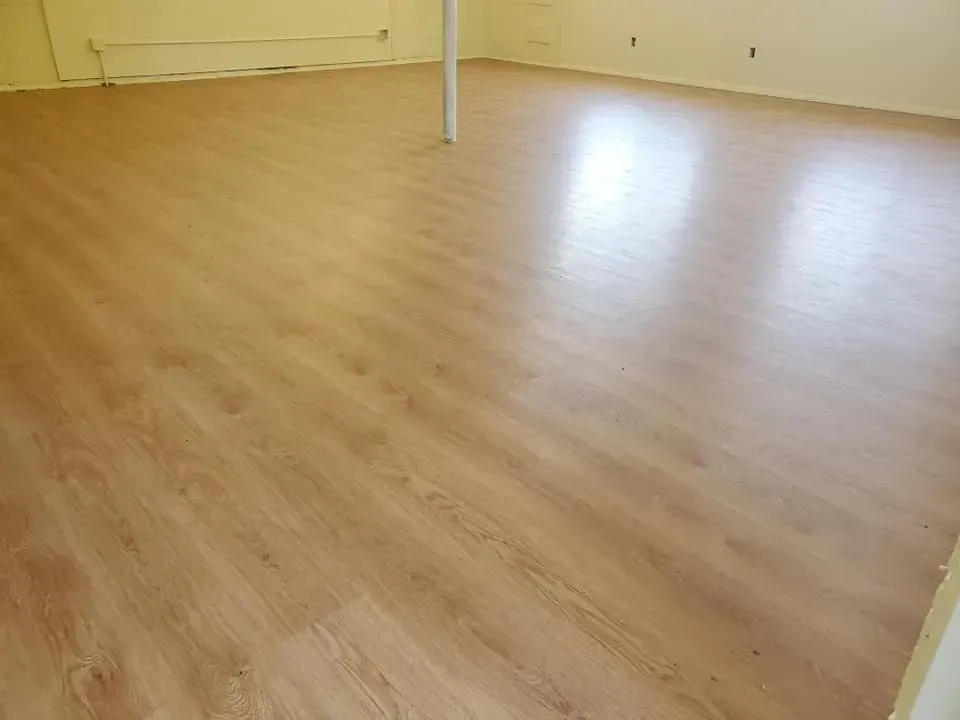 A large room with a wooden floor and white walls.