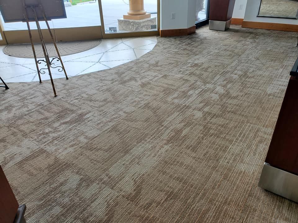 A room with a carpeted floor and a painting easel.