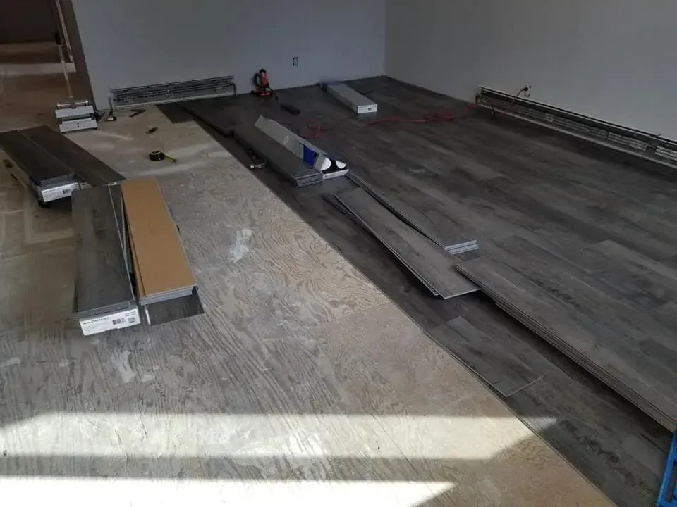 A room with a wooden floor being installed in it.