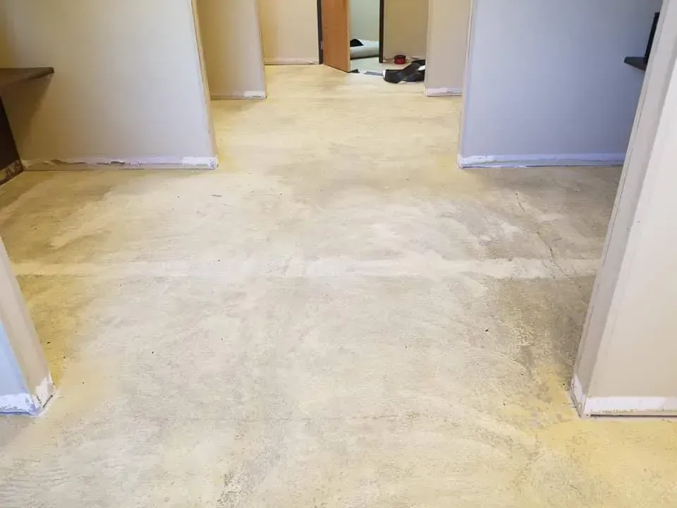 A room with a dirty carpet and a dirty floor.