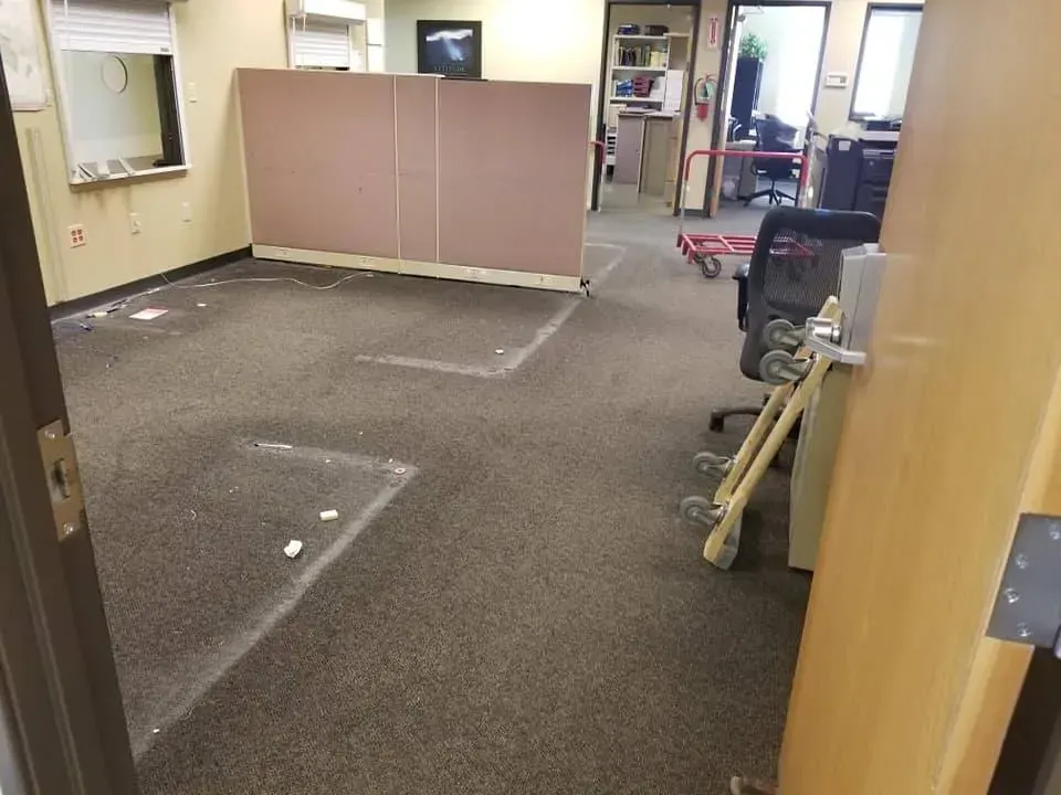 A room with a carpeted floor and a wooden door.