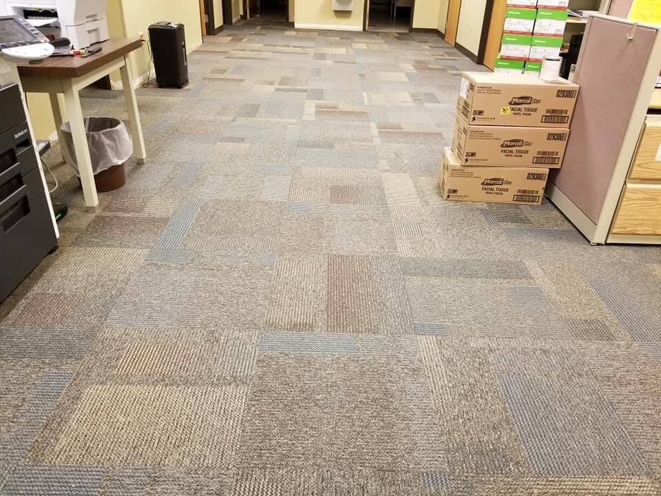 A carpeted floor in an office with boxes stacked on top of it.