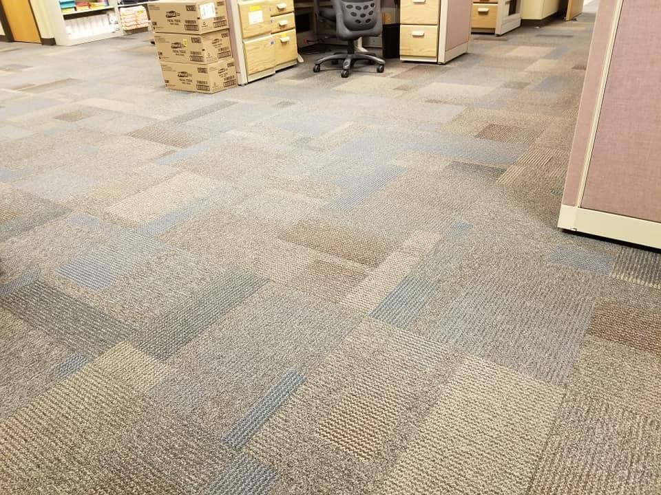 A carpeted floor in an office with a desk and chair