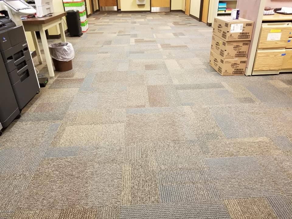 A carpeted floor in an office with boxes on it.