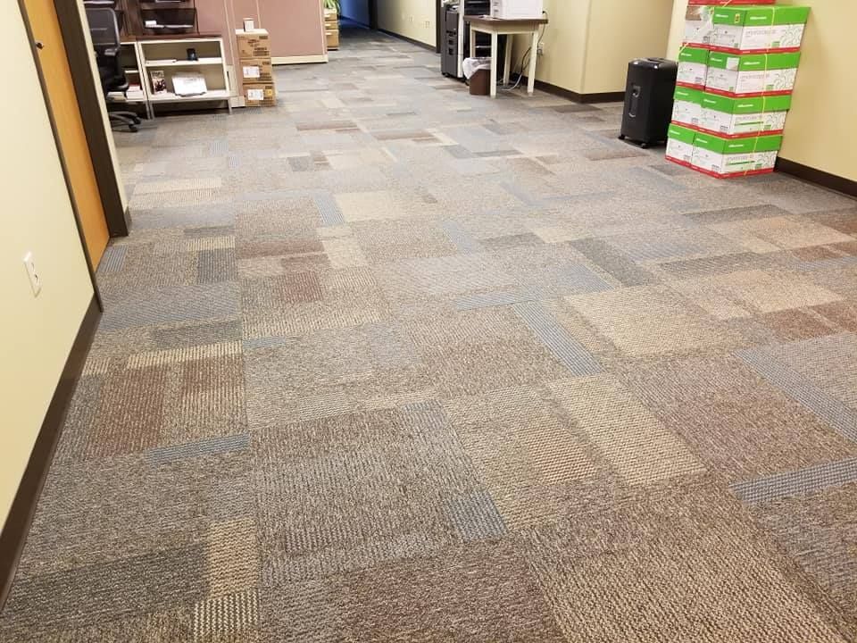 A hallway with a carpeted floor and boxes on the wall.